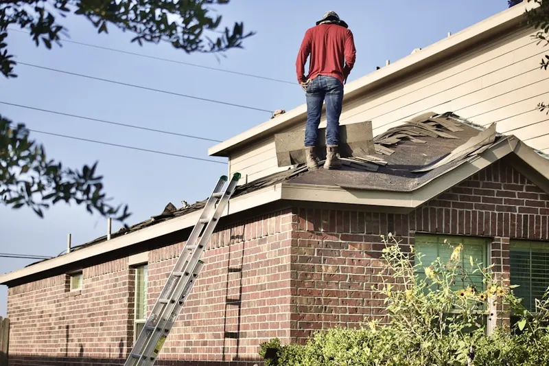 Professional roofer working on a residential roof in Atoka